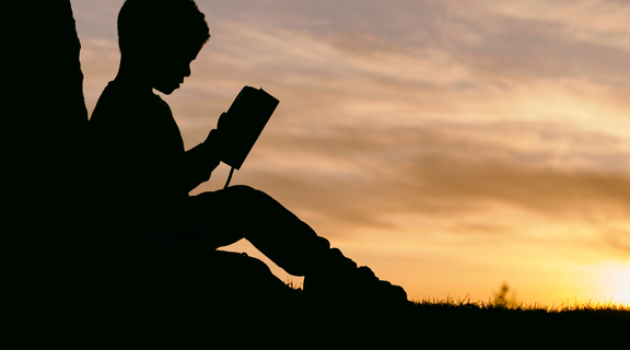 Homepage canva   silhouette of a kid reading at sunset