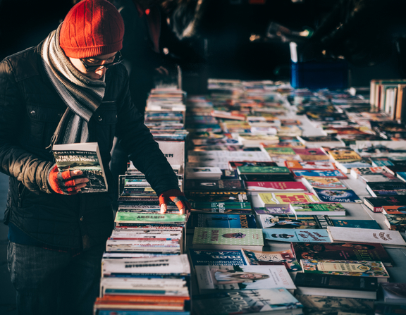 Large canva   person holding book while browsing on book lot