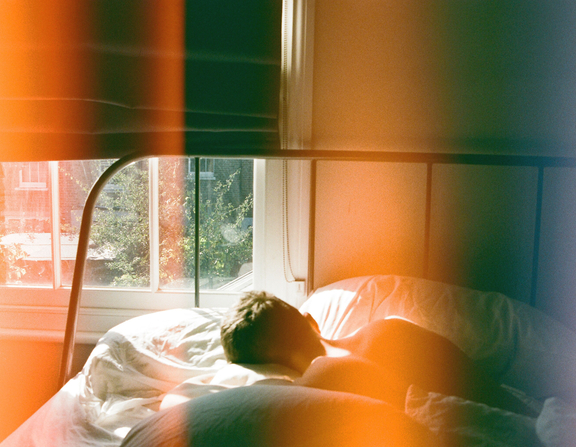 Large canva   person lying in bed beside window